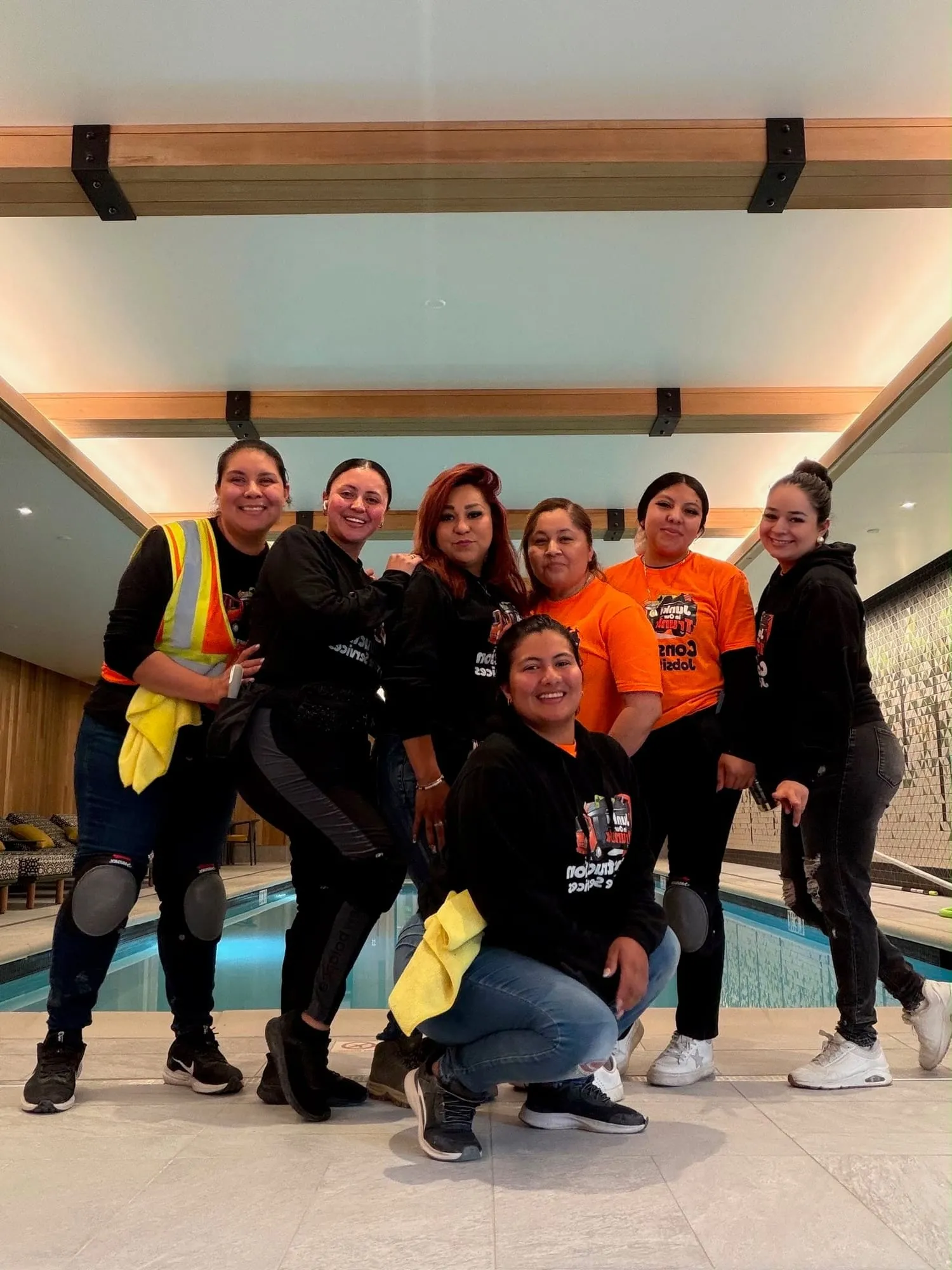 Cleaning crew in orange shirts in a finished hotel pool area