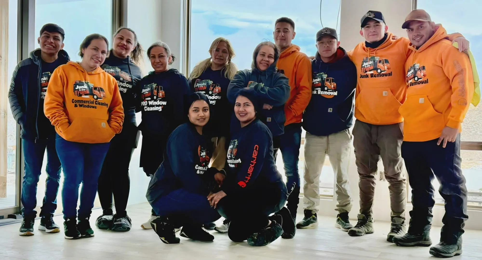 Junk In Our Trunk cleaning crew in branded hoodies inside a finished build