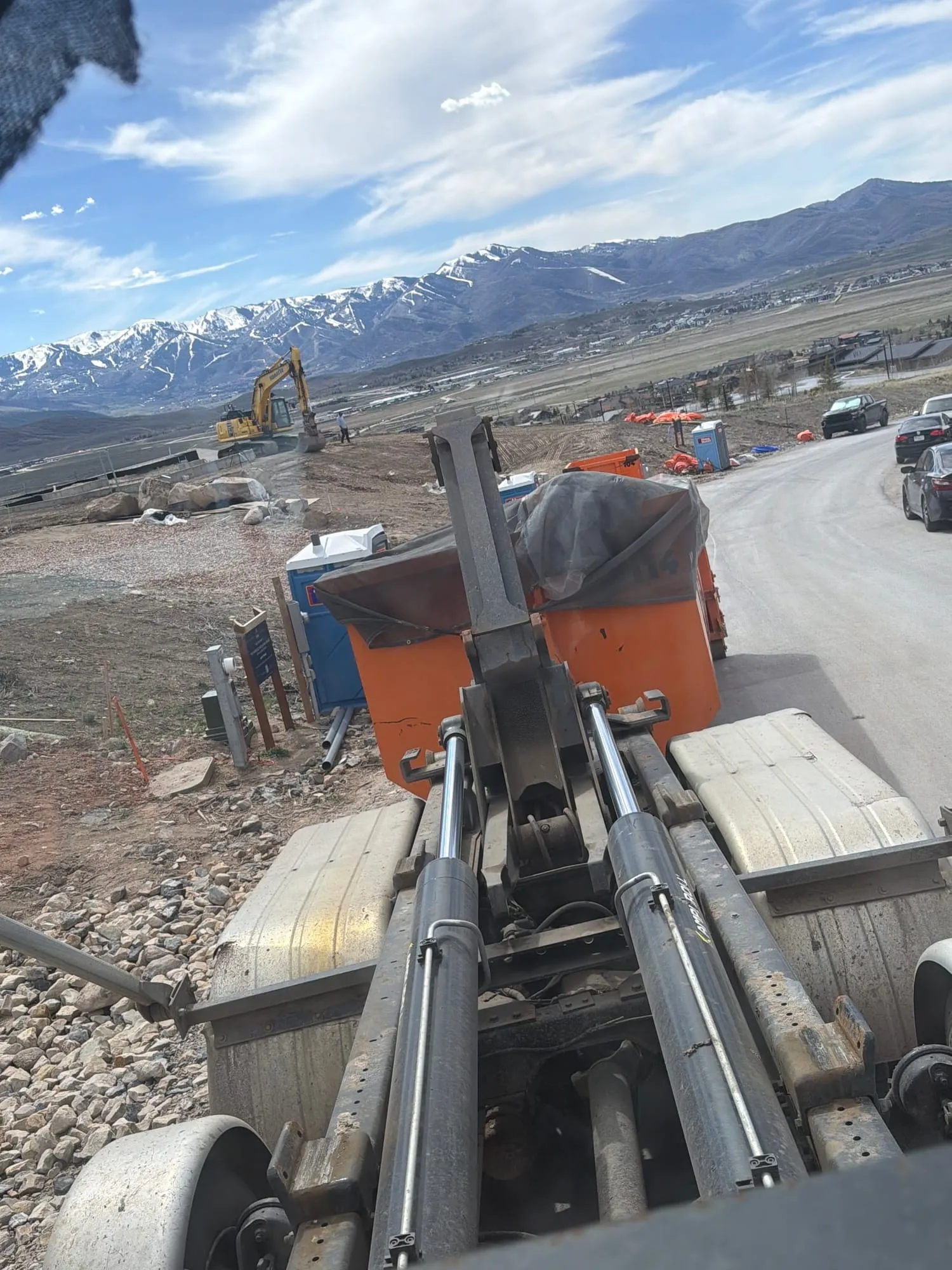View down the truck's hook arm over a busy jobsite
