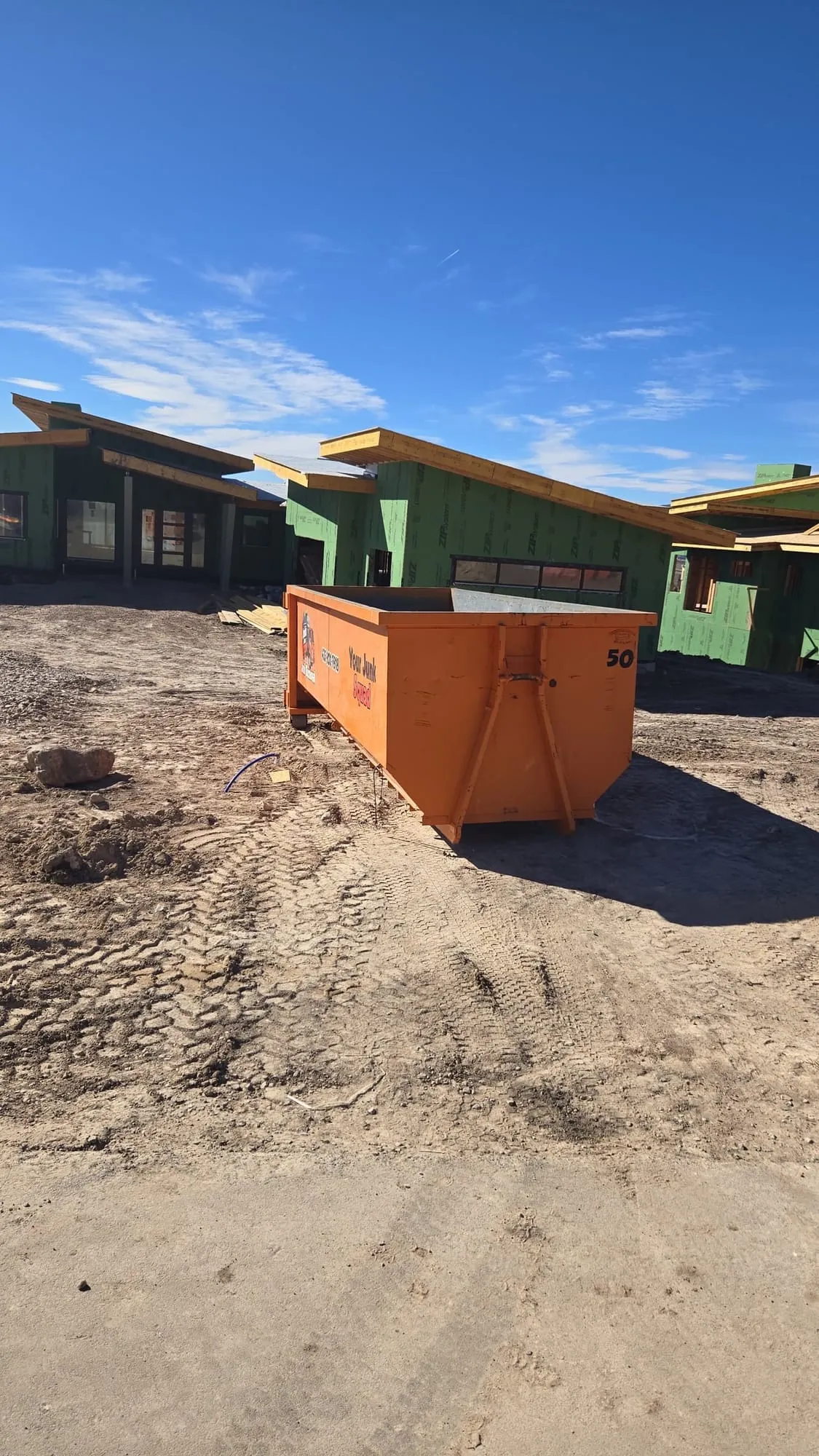 Dumpster among homes being framed