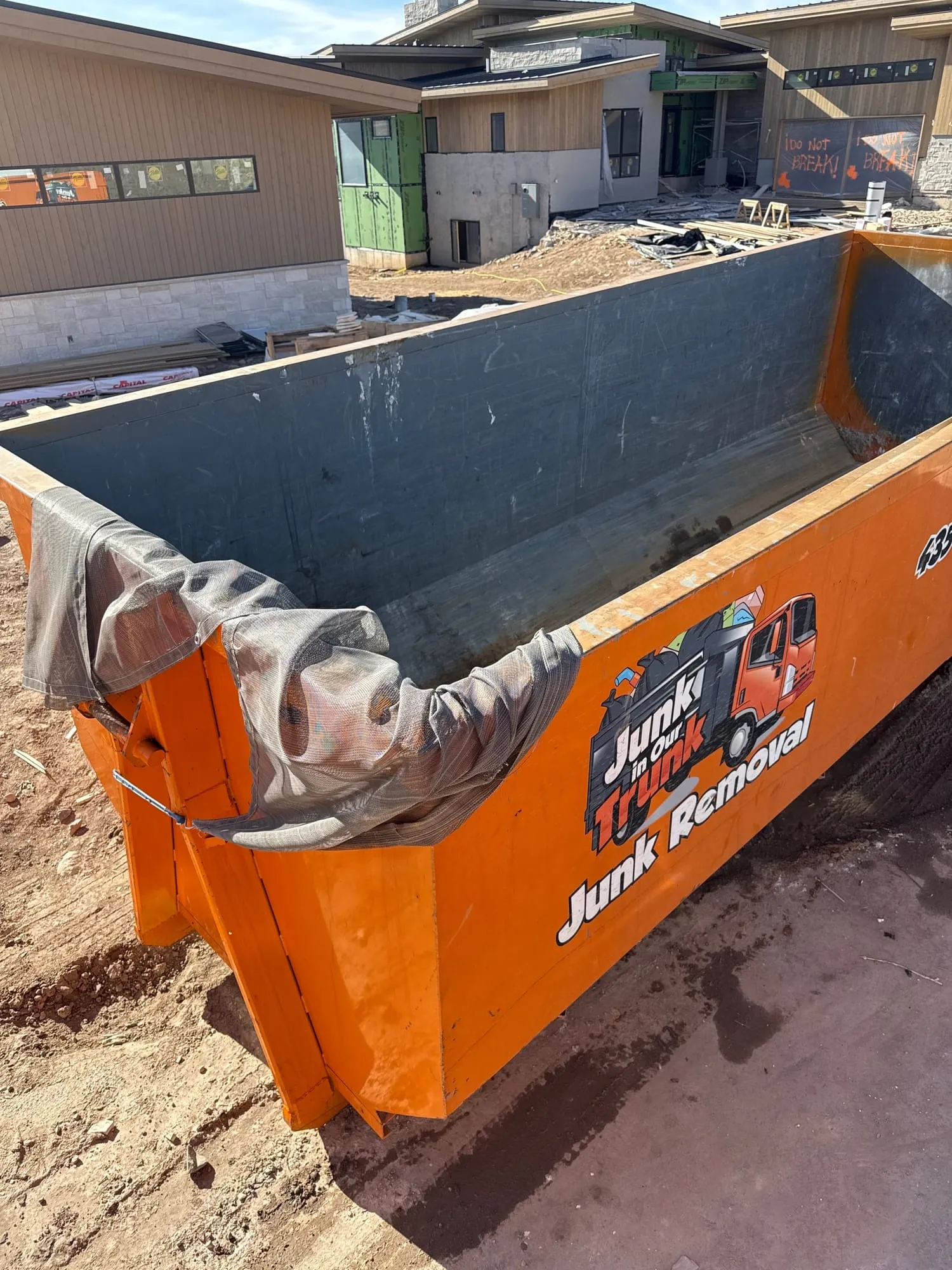 Empty lined dumpster in front of a luxury home under construction