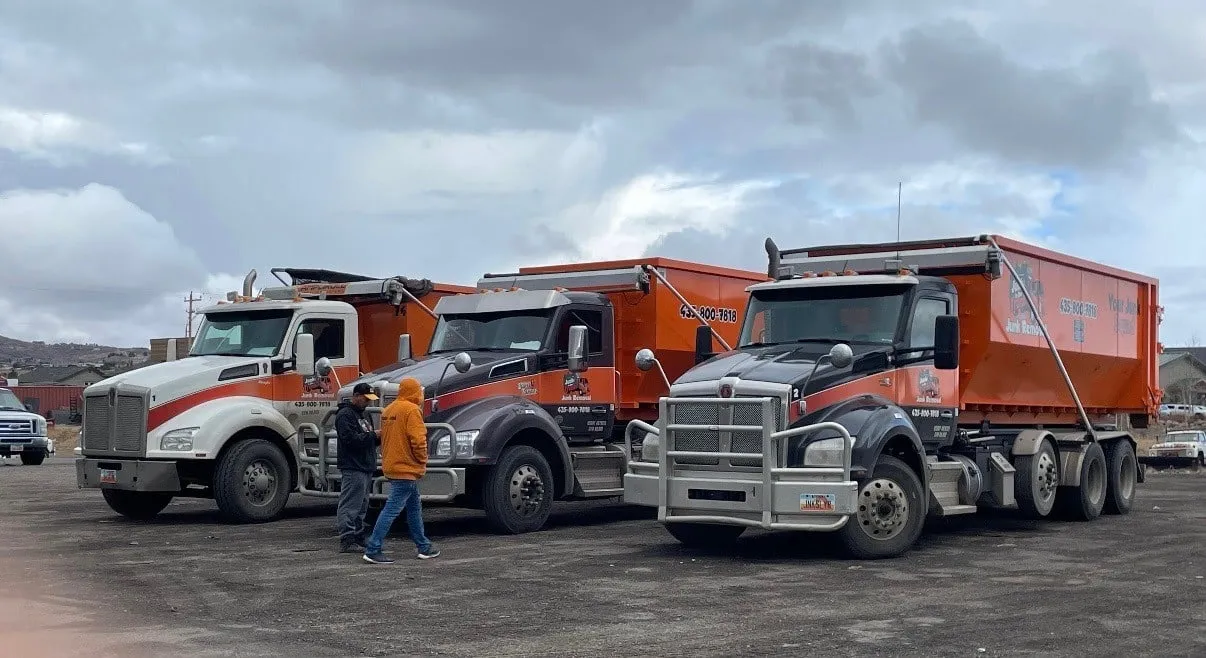 Three Junk In Our Trunk roll-off trucks lined up